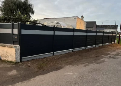 Longue clôture aluminium anthracite avec liseré gris clair sur soubassement béton dans la Somme