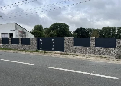 Portail battant aluminium anthracite intégré dans un mur de gabions dans la Somme